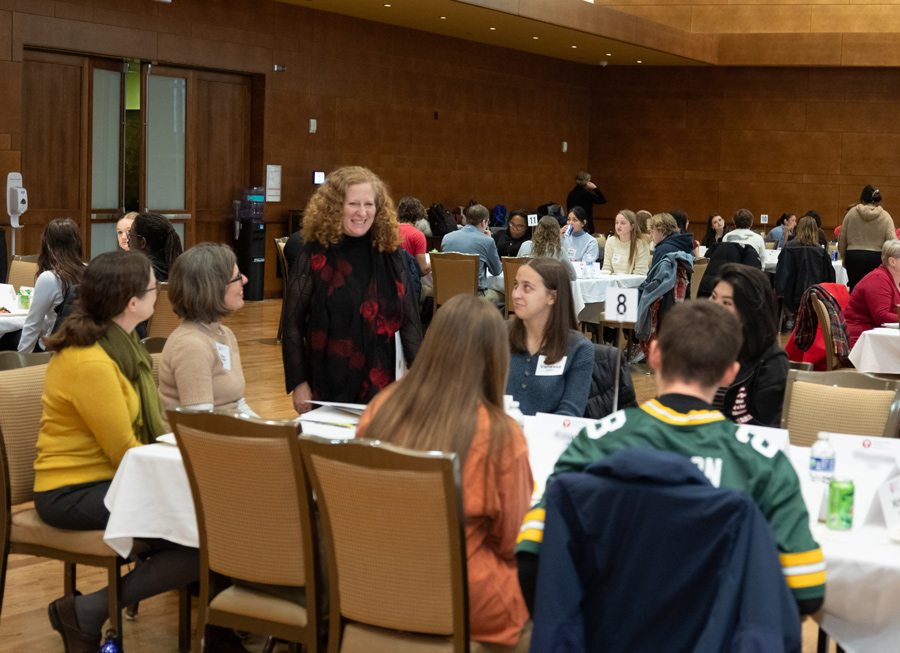 Chancellor Mnookin stands at a table with a group of students